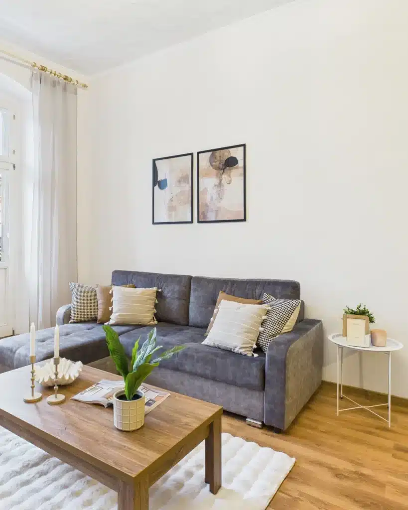 Salon z szarą sofą i stolikiem w mieszkaniu przygotowanym do prezentacji